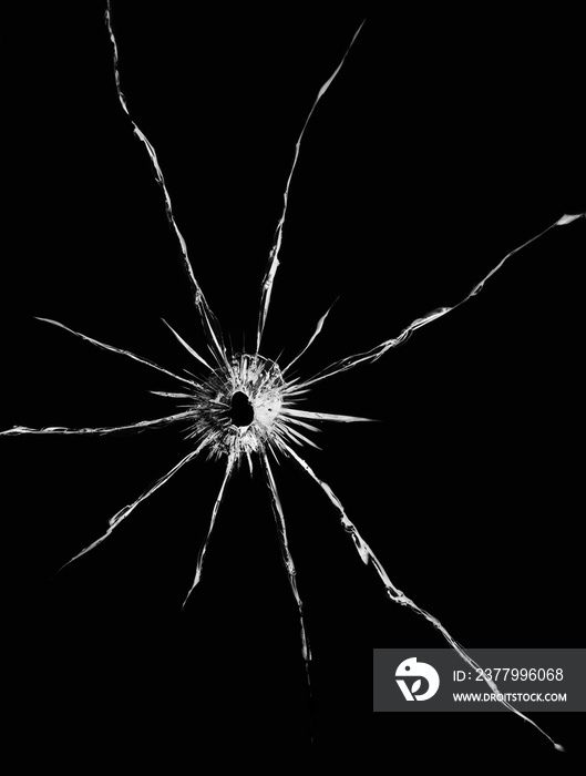 Texture of cracks on the glass from the shot. Cracked glass for design. Cracks on a black background