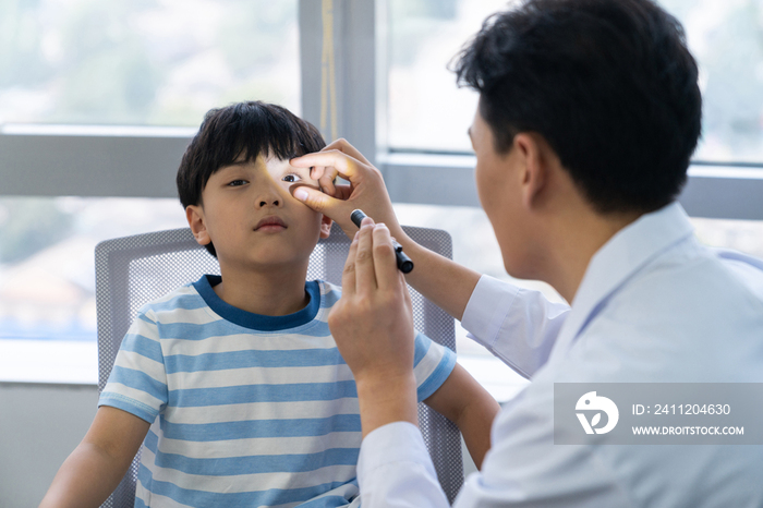 眼科大夫给小男孩检查眼睛