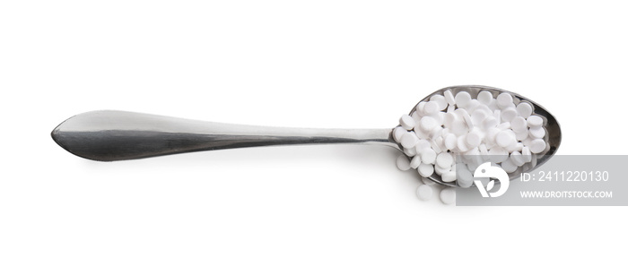 Metal spoon with stevia pills on white background