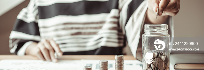 Financial businesswoman with coins put in a jar, Saving money for future growth and knowing how to manage your spending wisely, Saving money for business growth or long-term profitability.