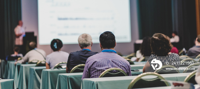 Audience in lecture hall participating at business conference event