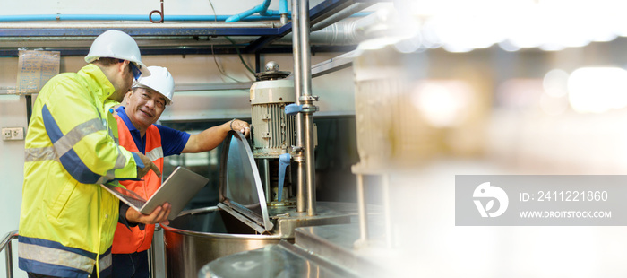 Professional Asian mechanical engineer inspecting the machines in the automated manufacturing factory.