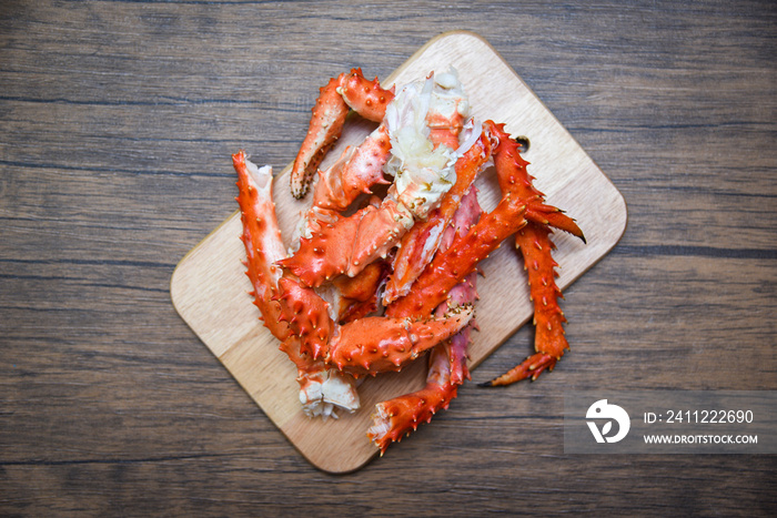 Alaskan King Crab Legs cooked seafood on wooden cutting board background - red crab hokkaido