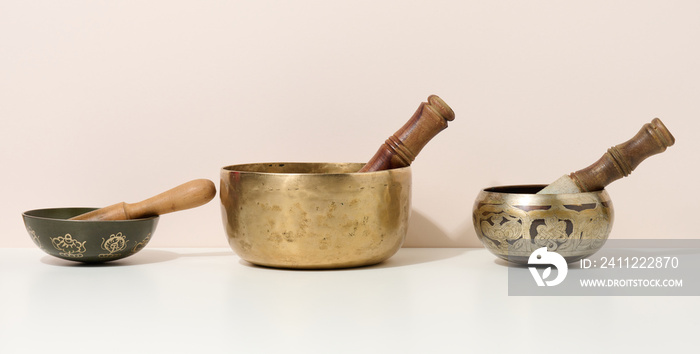 copper singing bowl and wooden clapper on a white table. Musical instrument for meditation, relaxation, various medical practices related to biorhythms, normalization of mental health