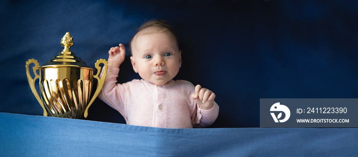 two month old baby with golden cup, victory concept, panoramic mock-up image