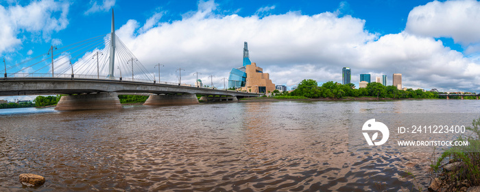 Panoramic dramatic arching skyline of Esplanade Riel Footbridge and The Canadian Museum for Human Rights over the Red River in Winnipeg, Canada.