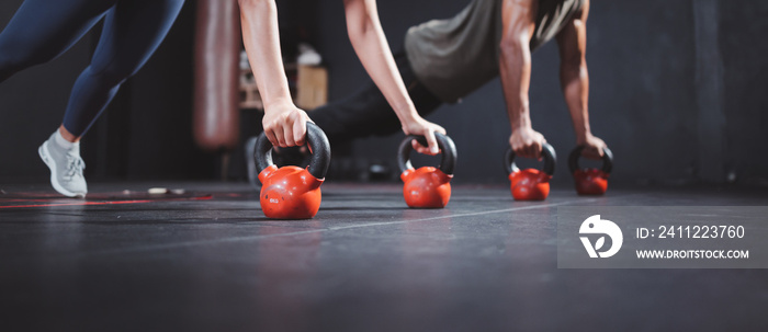 Banner size of Confident people doing push-ups during cross training at gym. Push-up on weights.