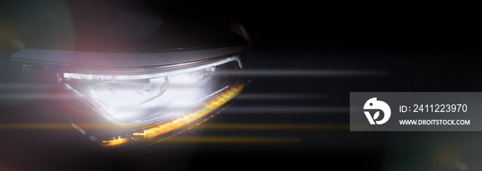 Headlight of a modern car in dense fog against dark background. Exterior details and beauty of technical innovations. Negative space to insert your text or image. Flyer for ad.