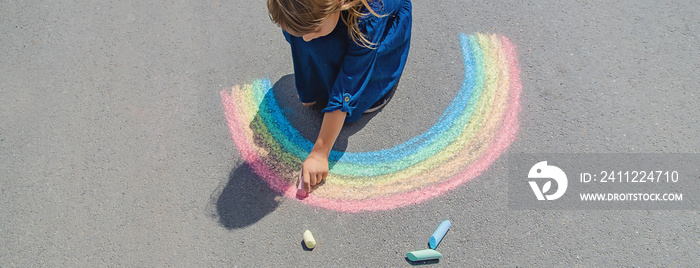 child draws with chalk on the pavement. Selective focus.