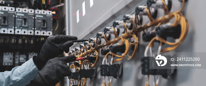 Electricity and electrical maintenance service, Close-up circuit breaker has engineer using measuring equipment checking electric volt at terminal block and cable wiring main power distribution board.