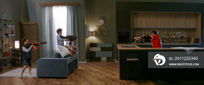 WIDE Kids having a toy gunfight with their father at home. Family having fun during quarantine, playing together. Shot with anamorphic lens