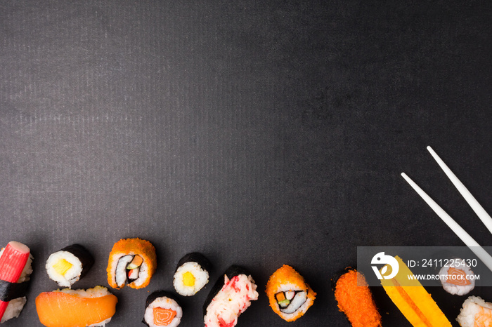 Top view of Sushi set and chopsticks on black background, Japanese food. Free space for text