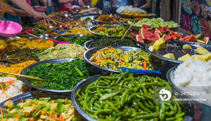 Street food in Luang Prabang, Laos. Delicious food stall selling colorful vegetable dishes to tourist. Asian cuisine, tasty food, healthy lifestyle.