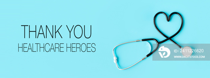 Thank you healthcare heroes message with stethoscope forming a heart on pastel blue background. Health and Covid-19concept.