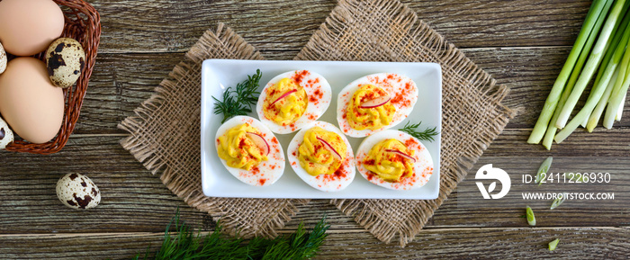 Deviled eggs. Delicious appetizer. Boiled eggs stuffed with yolk, mustard, mayonnaise, paprika. Classic recipe. The top view. Banner