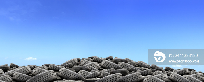 pile of used rubber tires with over light in blue sky background