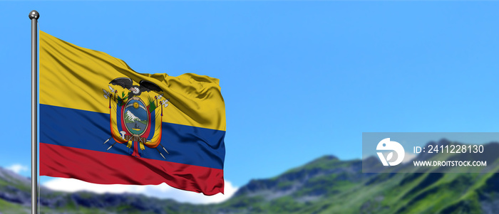 Ecuador flag waving in the blue sky with green fields at mountain peak background. Nature theme.