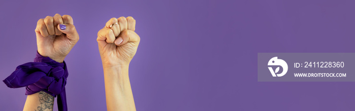 Mano de mujer con señas sobre fondo morado con paleacate o bandana del día de la mujer.