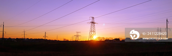 Panorama of high voltage distribution power lines pylon at sunset