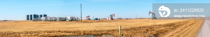 Gas oil distribution station with cisterns and a compressor on a yellow field with pumps pumping oil