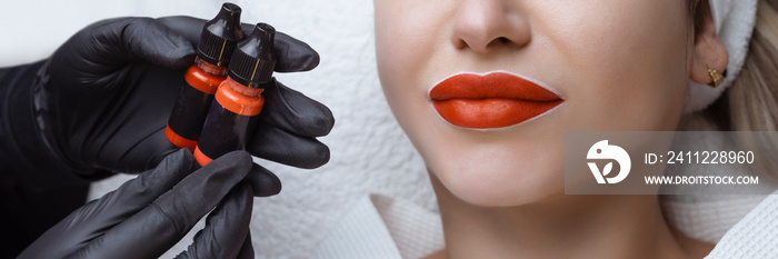 Lip tattooing. Permanent lip makeup cosmetologist keeps black gloves pigment paint for tattooing