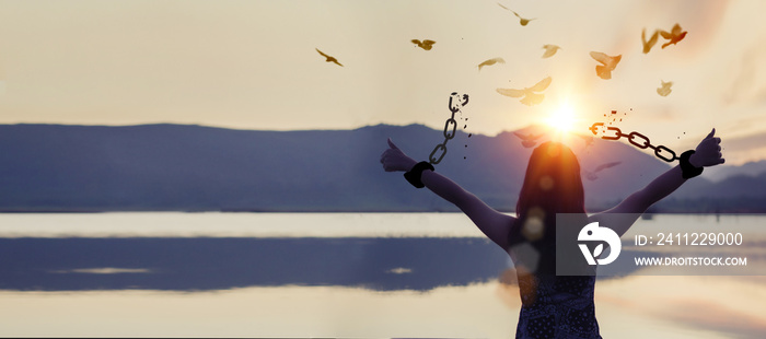 The woman who broke the chains and set the birds free enjoys nature at sunrise. concept of freedom