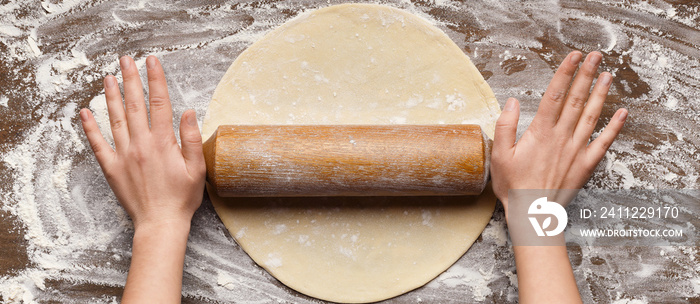 Chef rolling dough for pizza on table