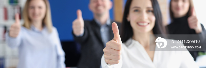 Business leaders with group of employees showing thumbs up