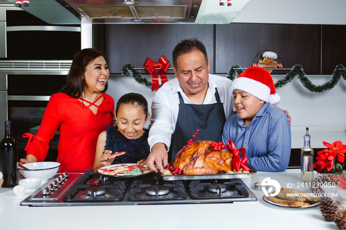 Mexican famiy with kids cooking Christmas eve turkey and eating cookies