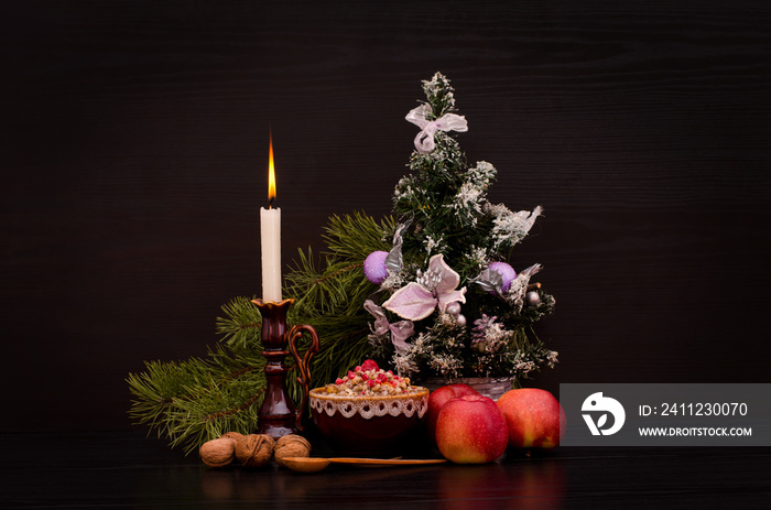 Christmas kutia Traditional Slavic sweet dish. Candle, apples and Christmas tree on a black backgrou