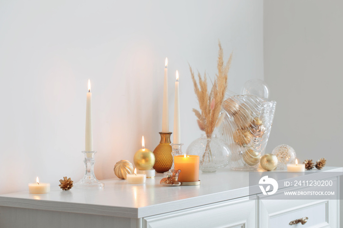 christmas decorations with burning candles in white room