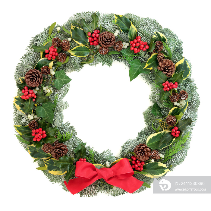 Winter and Christmas wreath with snow covered spruce pine fir, red bow, mistletoe, pine cones, cedar