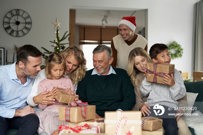 Multi generation caucasian family opening Christmas presents at home