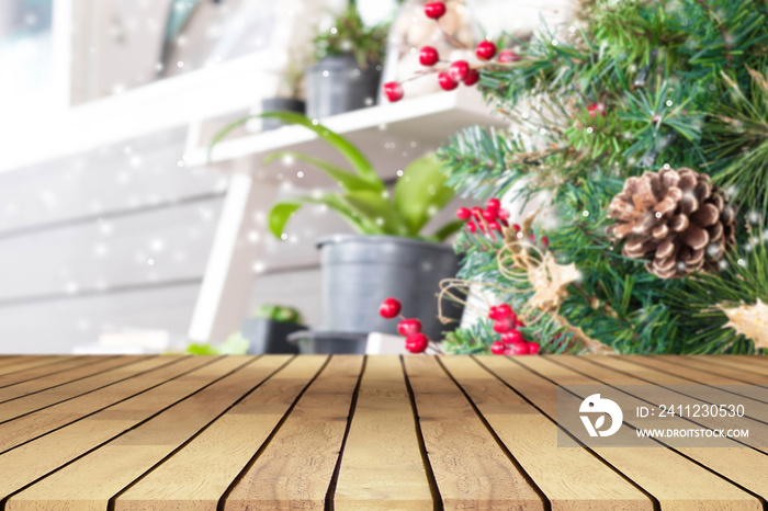 Perspective empty wooden table and christmas tree with snowing and blur decoration at coffee shop ba