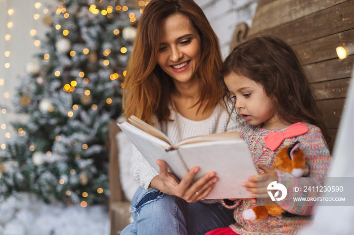 Mother and daughter reading on Christmas eve