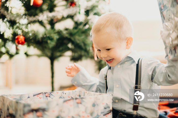 Infant boy opening Christmas present