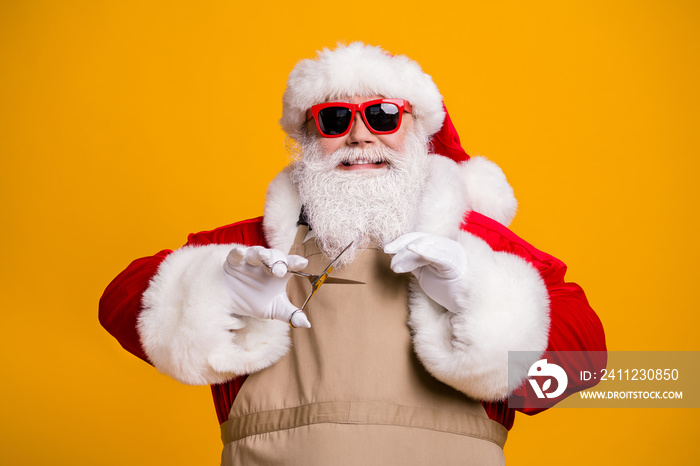 Close-up portrait of nice attractive cheerful cheery grey-haired Santa wearing apron cutting fixing 