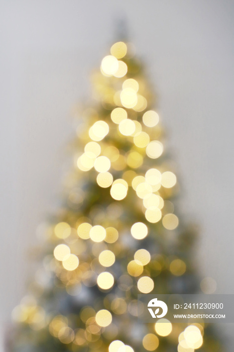 Blur light celebration on christmas tree with white wall background. Defocus holiday background.