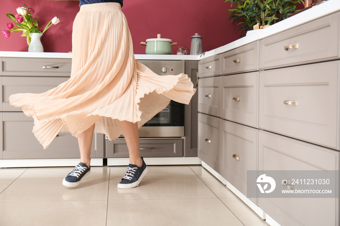Young woman dancing in modern kitchen