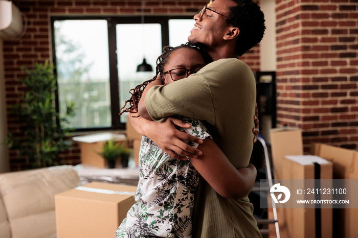 African american couple sharing hug and enjoying property relocation, having romantic moment after m