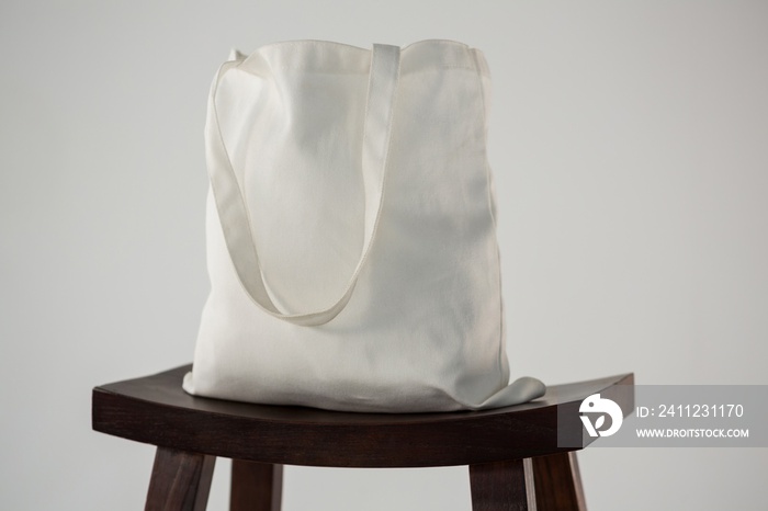 White bag on wooden stool