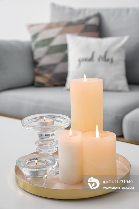 Burning candles on table in living room, closeup