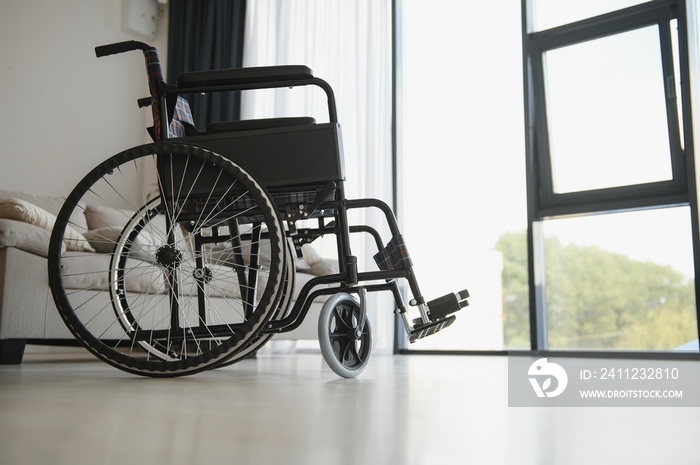 Empty wheelchair in living room next to the couch