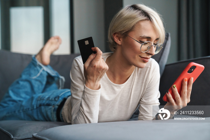 Smiling blonde mid aged woman shopping online