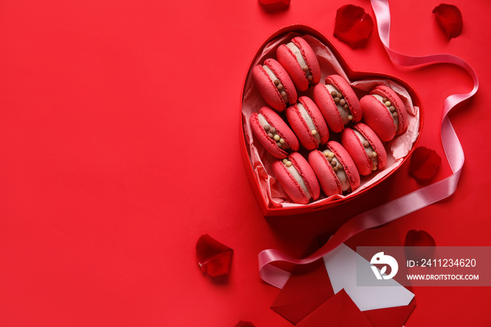 Box with tasty macaroons, envelope and rose petals on red background. Valentines Day celebration