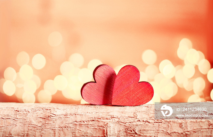 Hearts on a wooden branch and background is a bokeh.