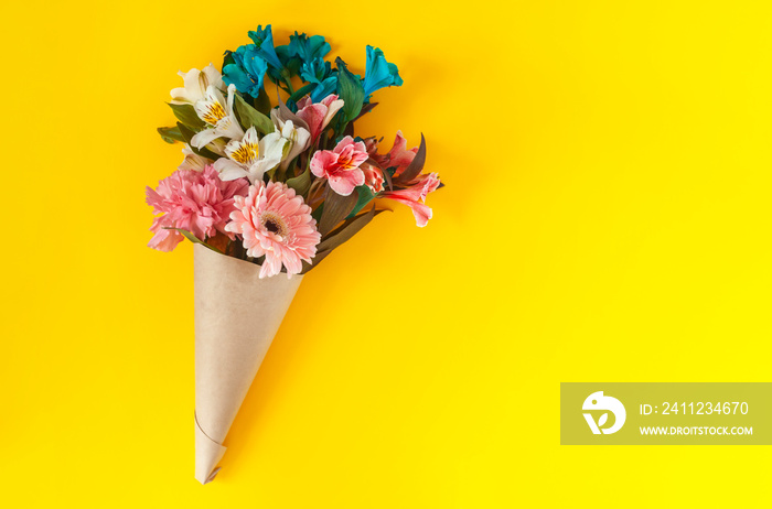 A bouquet of fresh spring flowers on the bright yellow background. Top view of spring floral backgro