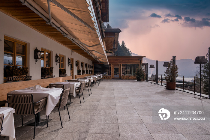 Tables and chairs arranged by windows. Beautiful outdoor place setting at restaurant against sky. Ex