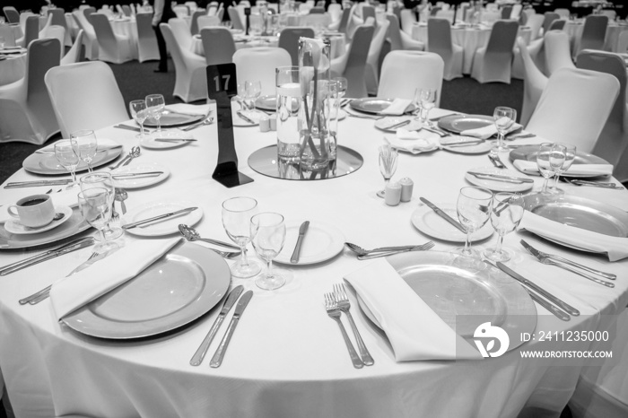 A grayscale shot of decor and set-up for dinner in the conference hall.