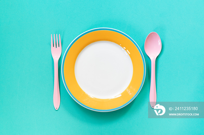 Empty color plates or dish on green table background, top view food concept